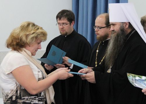 Митрополит Георгий и руковоритель СарФТИ А Сироткина вручают свидетельства педагогам