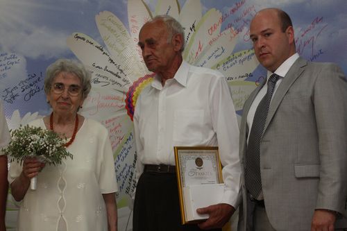 Д.Вдовых вручает грамоту супругам Тумановым